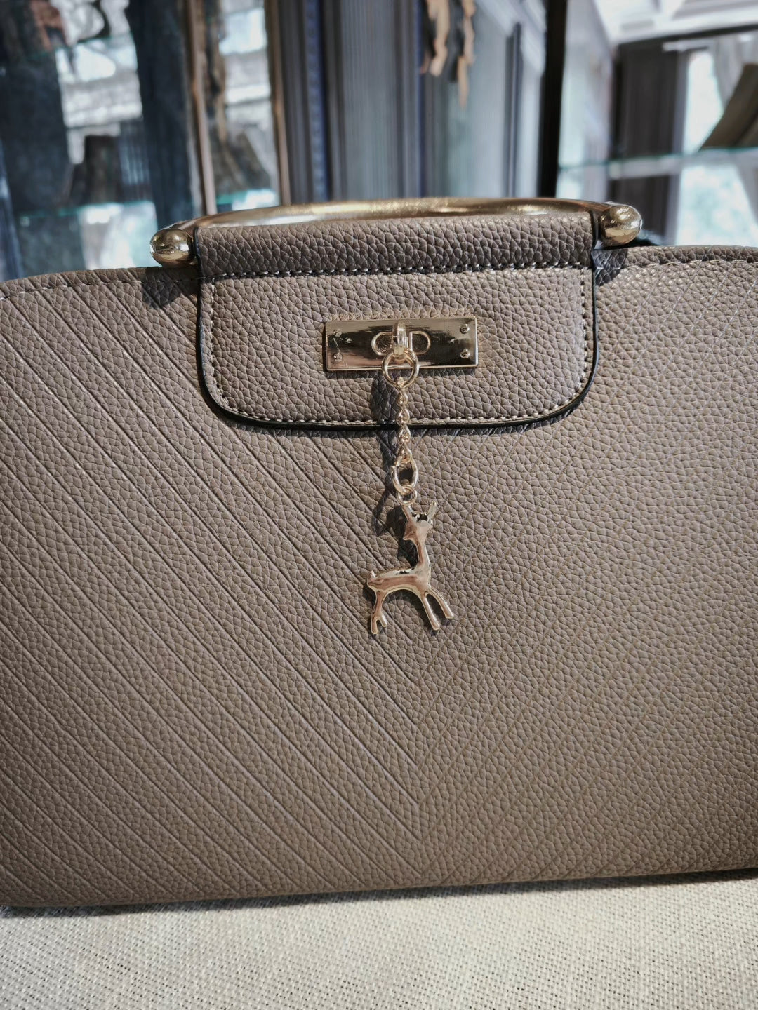 Taupe Textured Top-Handle Boston Bag with Golden Deer Charm and Detachable Strap