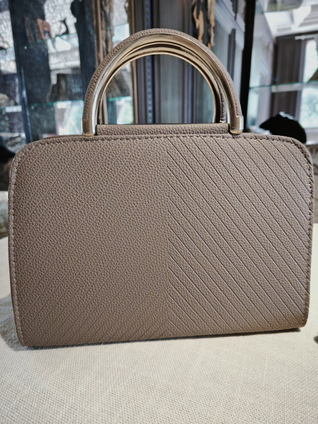 Taupe Textured Top-Handle Boston Bag with Golden Deer Charm and Detachable Strap