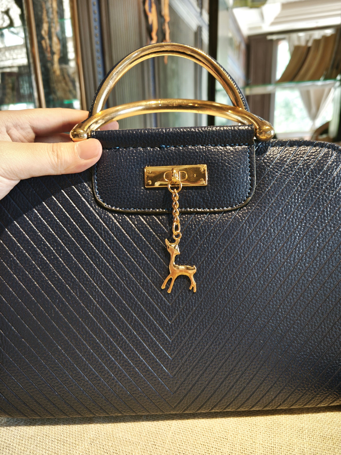 Navy Blue Textured Top-Handle Boston Bag with Golden Deer Charm and Detachable Strap